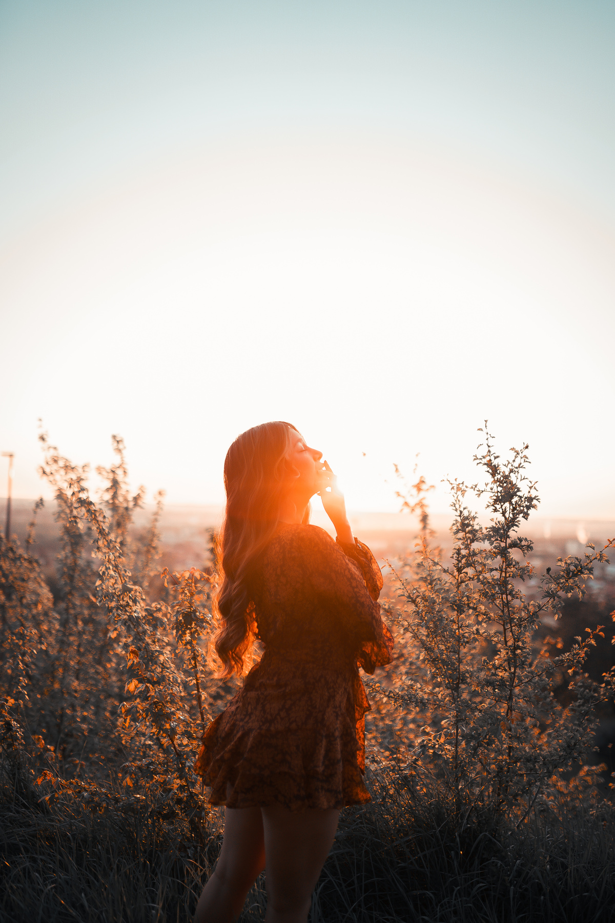 Gentle woman standing in nature in sunlight